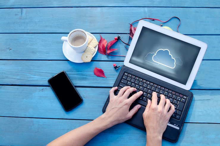 Foto manos trabajando en computadora portátil con tecnología de nube en pantalla