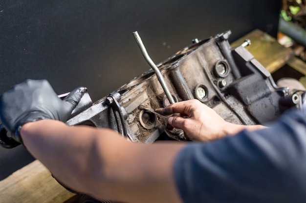 Manos trabajando en el motor de un automóvil. Limpieza de un motor de automóvil. Taller mecánico