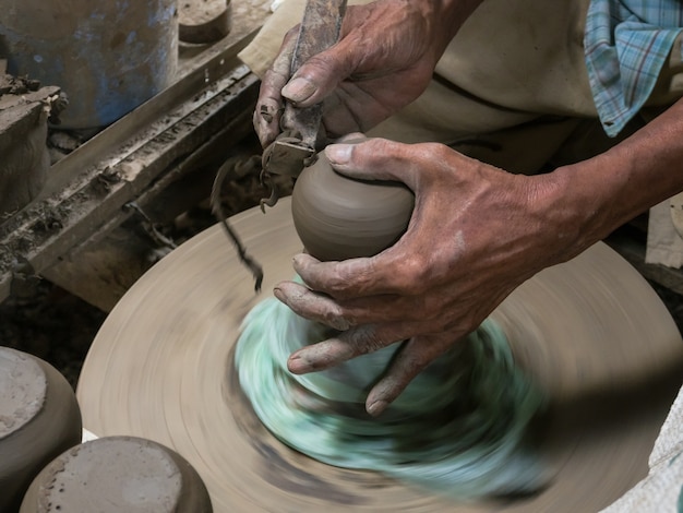 Foto manos trabajando en la rueda de alfarería