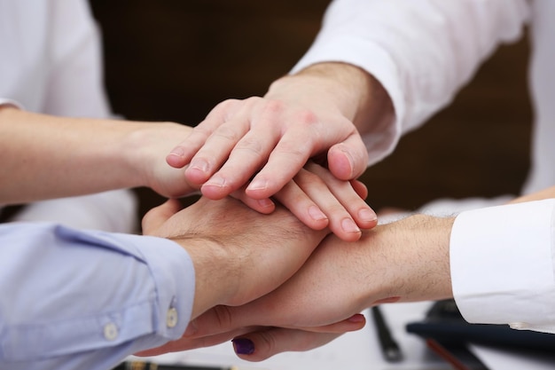 Foto manos unidas del equipo de negocios en el fondo del espacio de trabajo