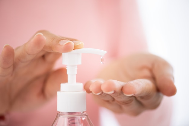 Manos usando un dispensador de bomba de gel desinfectante para la prevención de la enfermedad por Coronavirus (COVID-19).