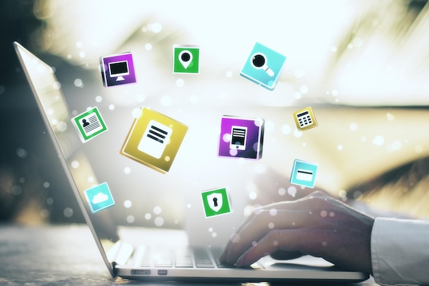 Manos usando laptop con iconos de redes sociales brillantes