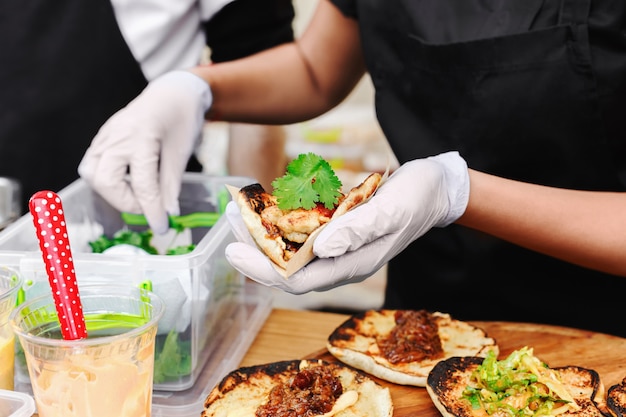 Manos de vendedor ambulante femenino haciendo taco