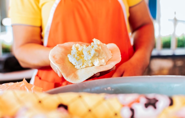 Manos de un vendedor mostrando pupusa cruda tradicional Elaboración de pupusas tradicionales elaboración de la masa para pupusas tradicionales nicaragüenses