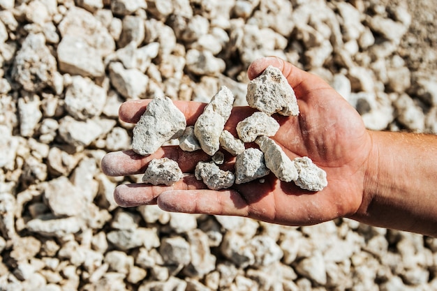 Manos de vista superior con piedras blancas luz áspera de cerca