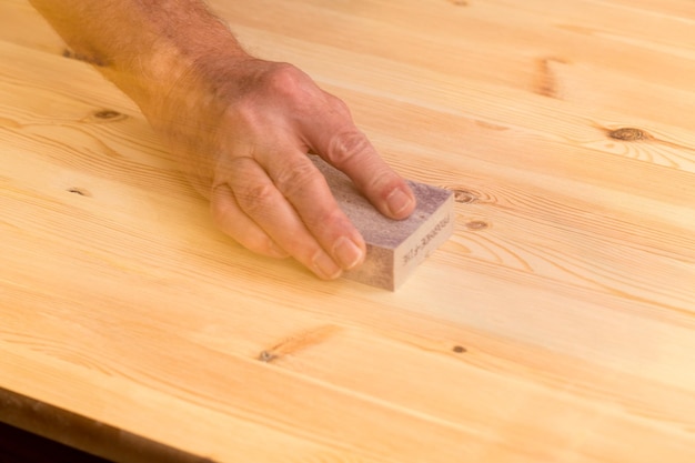 Mans mano en bloque de lijado en madera de pino