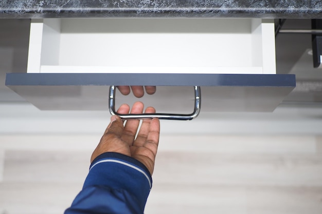 Mans mano cajón abierto de madera en el gabinete