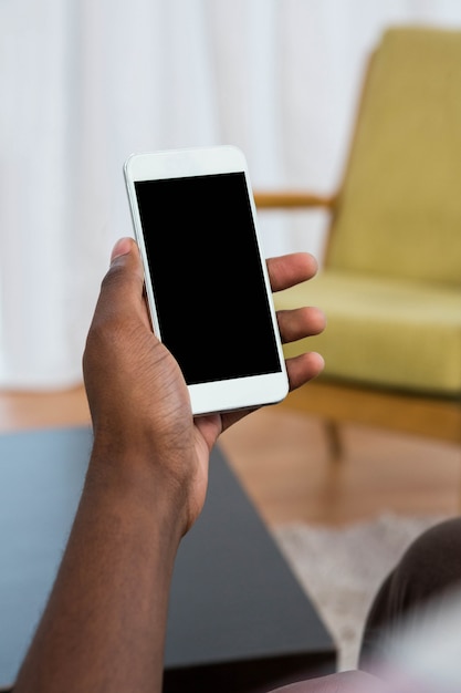 Mans mano sosteniendo un teléfono en casa