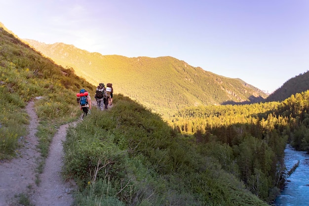 Mans senderismo en las montañas al atardecer con mochila pesada Travel Lifestyle wanderlust concepto de aventura vacaciones de verano al aire libre solo en la naturaleza