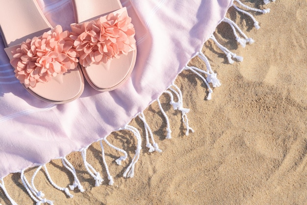 Manta con elegantes zapatillas en la playa de arena plana Espacio para texto