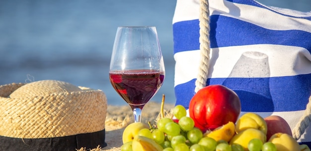 Manta de picnic, vino, fruta, hermosa playa de mar. Enfoque selectivo