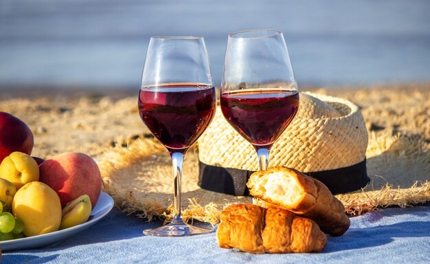 Manta de picnic, vino, fruta, hermosa playa de mar. Enfoque selectivo