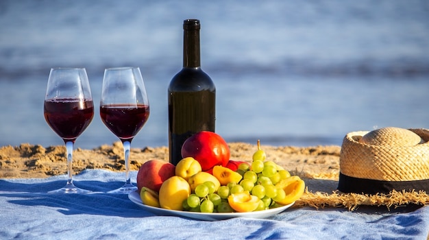 Manta de picnic, vino, fruta, hermosa playa de mar Naturaleza Enfoque selectivo