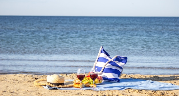 Manta de picnic, vino, fruta, hermosa playa de mar Naturaleza Enfoque selectivo