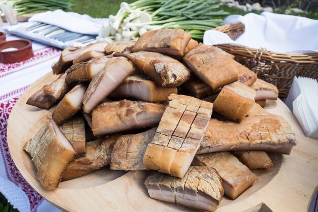 Manteca de cerdo ahumada (Slanina) sobre una placa de madera. Comida tradicional rumana.