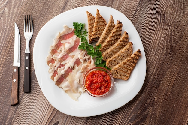 Manteca de cerdo picada cruda con carne una cabeza de ajo y pan de centeno sobre un fondo de madera para copiar espacio Un gran trozo de manteca de cerdo ucraniana fresca comida tradicional