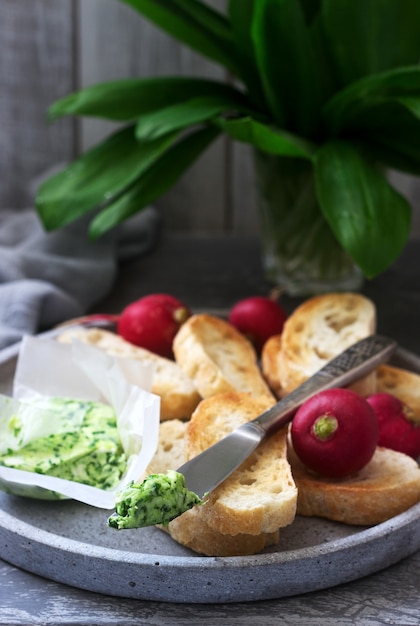 Manteiga com alho selvagem, fatias de pão e rabanete, ingredientes para fazer um sanduíche.