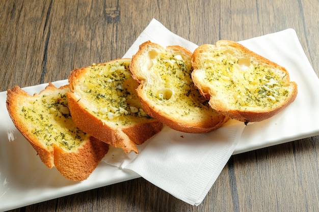 Manteiga de alho pão francês servido em prato isolado na mesa lanche