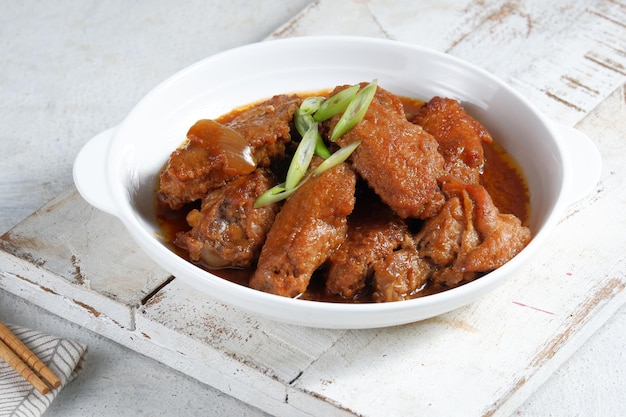 manteiga de frango frito ou chamado ayam goreng mentega, em chapa branca. cozinha indonésia.