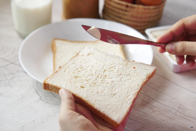 Manteiga espalhando em um pão de perto