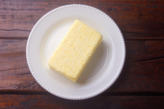Manteiga fresca fazenda orgânica amarela feita com leite de vaca na mesa de madeira rústica. comida caseira