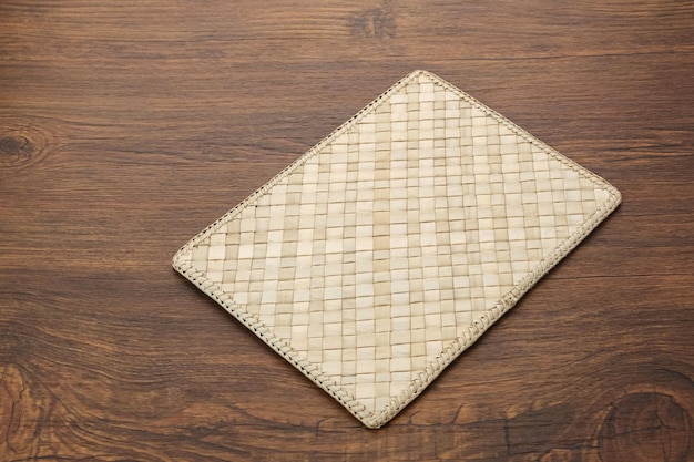 Mantel de bambú tejido sobre mesa de madera