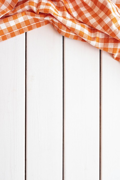 Mantel naranja a cuadros sobre fondo blanco de madera Vista superior del espacio de copia