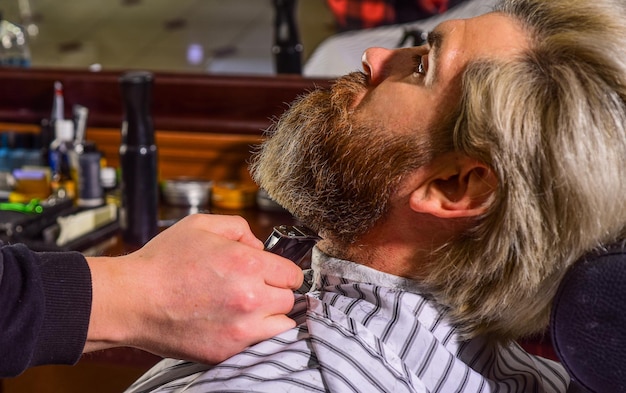 Mantener la forma de la barba Mejore su experiencia de corte de cabello Vello facial Hacer crecer la barba y el bigote Hombre en la barbería Peluquería Peluquero profesional y cliente Recortar la barba de cerca