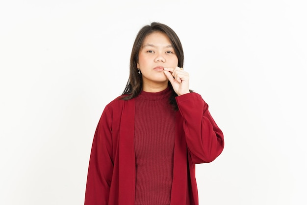 Mantener el labio secreto cerrado de hermosa mujer asiática vistiendo camiseta roja aislado sobre fondo blanco.