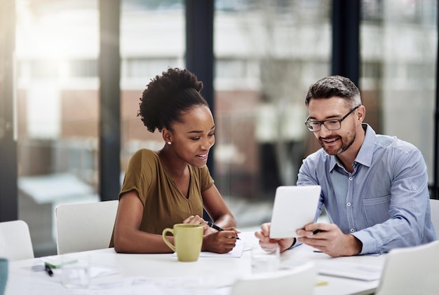 Mantenerse actualizado con todas las tendencias comerciales modernas Captura recortada de empresarios discutiendo algo en una tableta digital