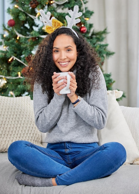 Mantenerse cómodo en casa Foto de una mujer joven tomando café durante la Navidad en casa