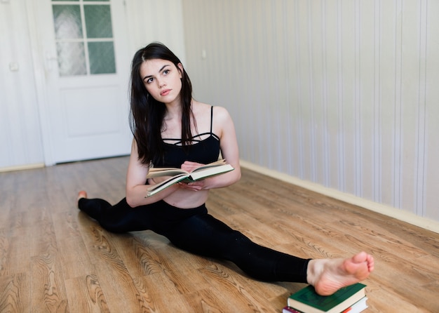 Mantenerse en forma y saludable. Hermosa mujer joven en ropa deportiva haciendo yoga mientras se relaja en casa