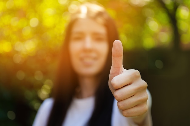 Foto manténgase positivo sonriente mujer dedo hacia arriba