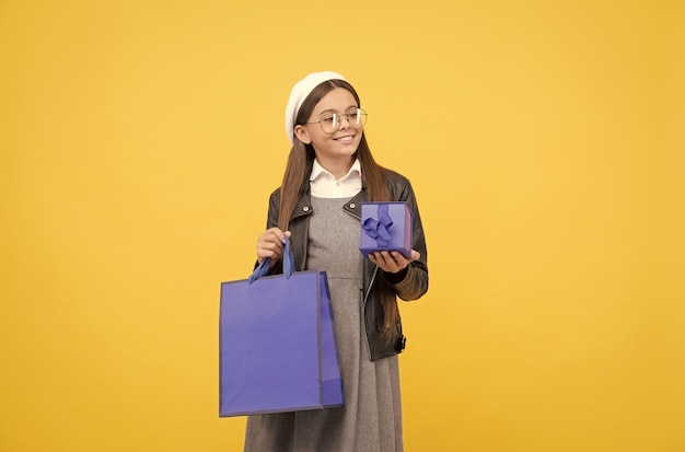 Mantenha a bolsa enquanto faz compras Criança feliz segura caixa de presente e sacola de compras De volta à venda da escola