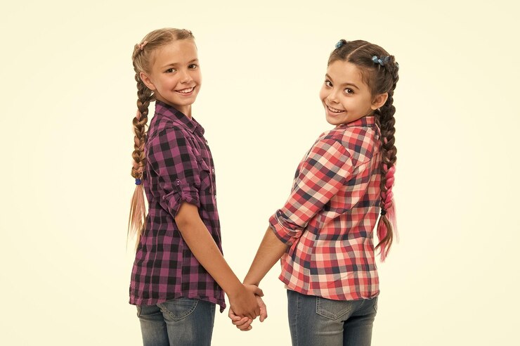 Foto mantenha o cabelo trançado irmãs com longos cabelos trançados salão de cabeleireiro divirta-se espírito rebelde penteados estilo escolar meninas tranças longas tendência da moda fofura da moda infância feliz