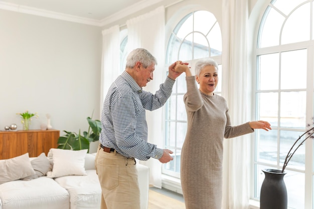 Foto mantenha-se em movimento romântico idoso casal maduro dançando para a música juntos em casa feliz família sorridente