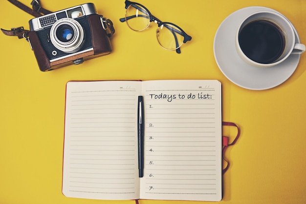 Mantenha-se organizado mantenha-se produtivo Captura de alto ângulo de um notebook com uma lista de tarefas em uma mesa amarela