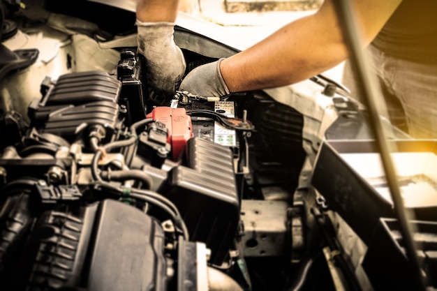 Foto el mantenimiento del coche selectivo se centró en la mano del trabajador arreglar algo del motor