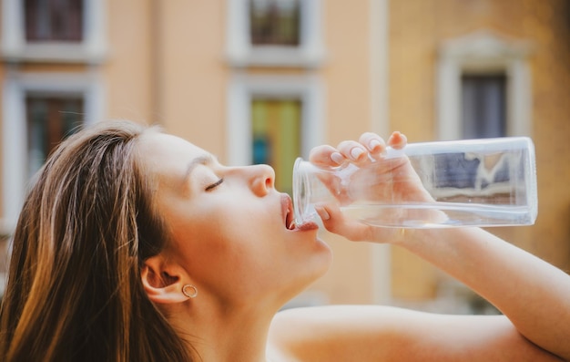 Mantente hidratado Chica bebiendo agua al aire libre Sensual joven Ciudad retrato Moda y belleza