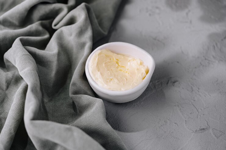 mantequilla cremosa fresca en un cuenco blanco sobre lino
