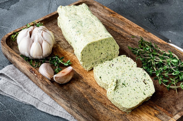 Mantequilla orgánica con una hierba para sándwiches y bistec sobre fondo de piedra gris