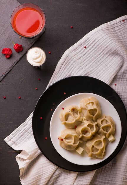 Manti ou manty dumplings em uma tigela tradicional na mesa de madeira.