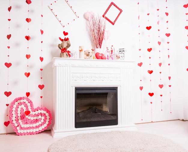 Manto de chimenea moderno en sala blanca decorada para el día de San Valentín con corazones