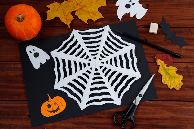 Manualidades de bricolaje de Halloween. Tela de araña cortada de papel. Creatividad infantil.