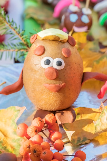 Manualidades para niños - oso de patatas y plastilina sobre hojas amarillas en un día soleado de otoño