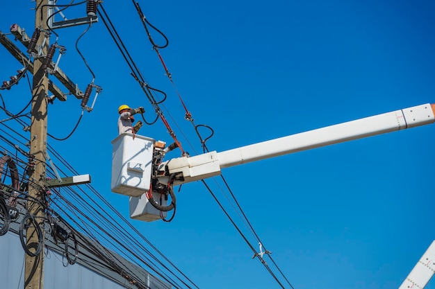 Manutenção de eletricistas trabalham com eletricidade de alta tensão na caçamba hidráulica