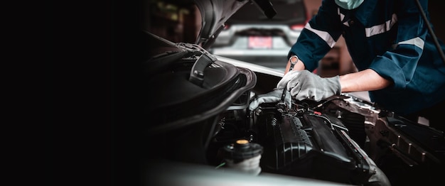 Manutenção e manutenção de cuidados com o carro técnico manual de closeup mecânico de automóveis usando a chave para reparar o problema do motor do carro de peças sobressalentes e suporte de serviço de seguro de carro