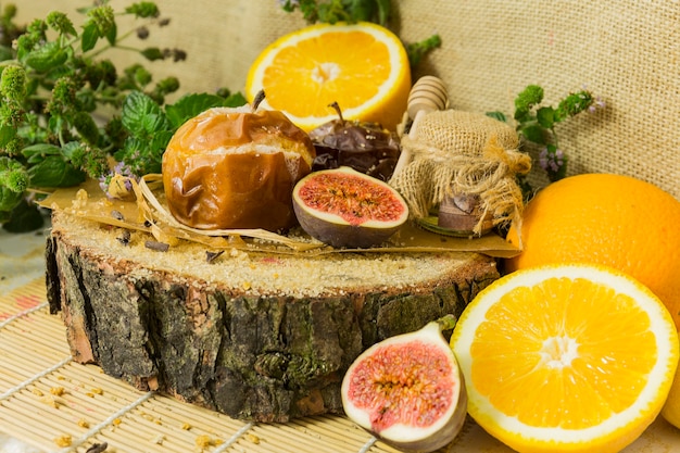 Manzana al horno, higo y naranja sobre superficie de madera