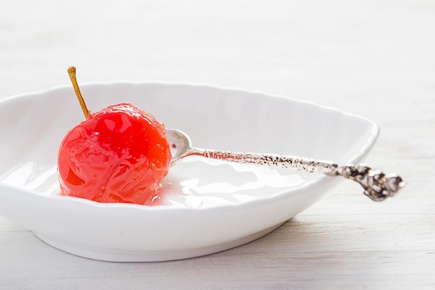 Manzana cocida en almíbar dulce sobre un fondo blanco.