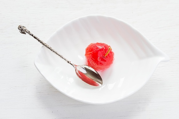 Manzana cocida en almíbar dulce sobre un fondo blanco.